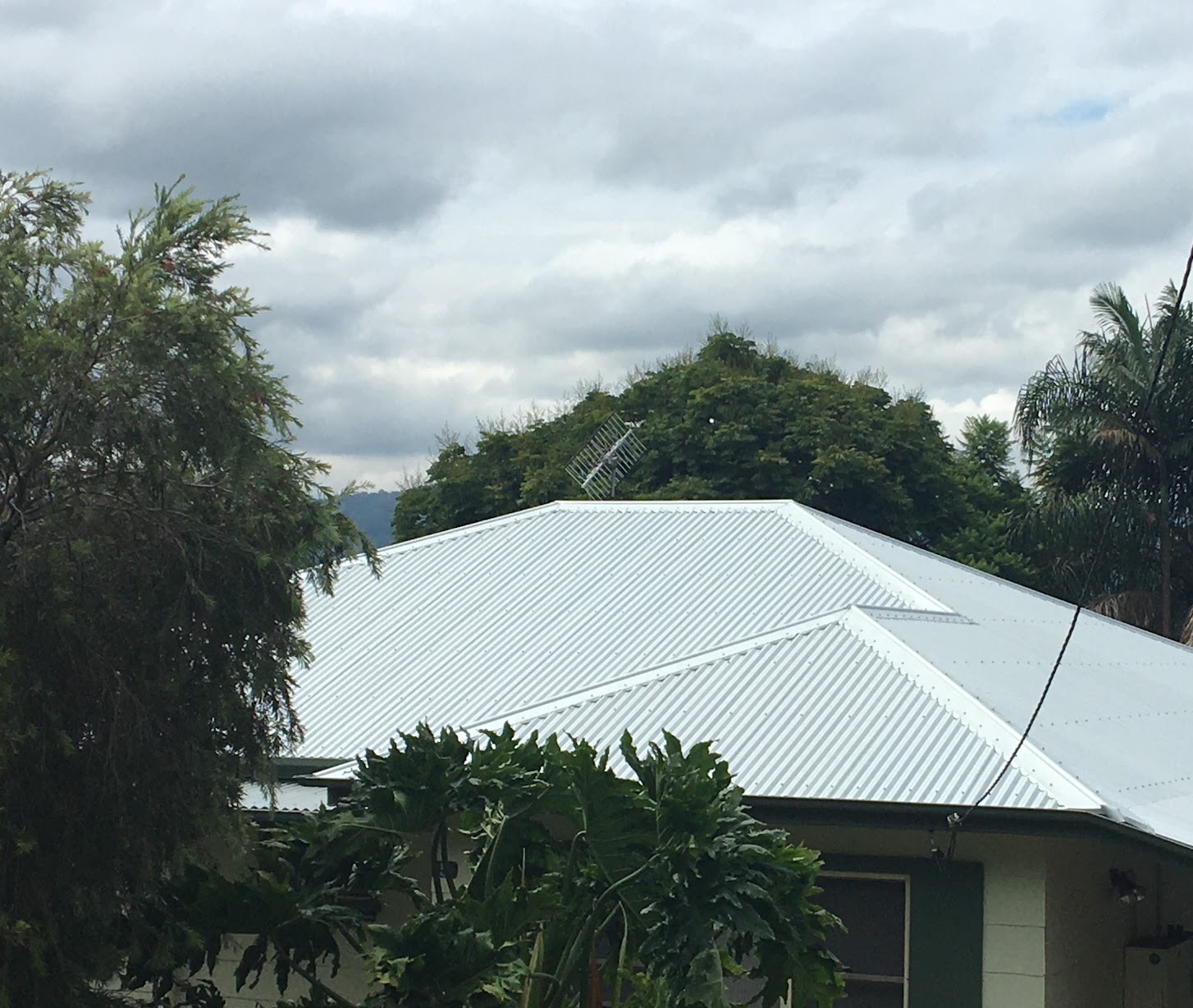 A fresh white metal roof finished on a weatherboard house